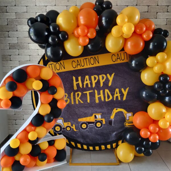 Décoration d'anniversaire thème camions avec ballons orange, noir et jaune par CinDéco.